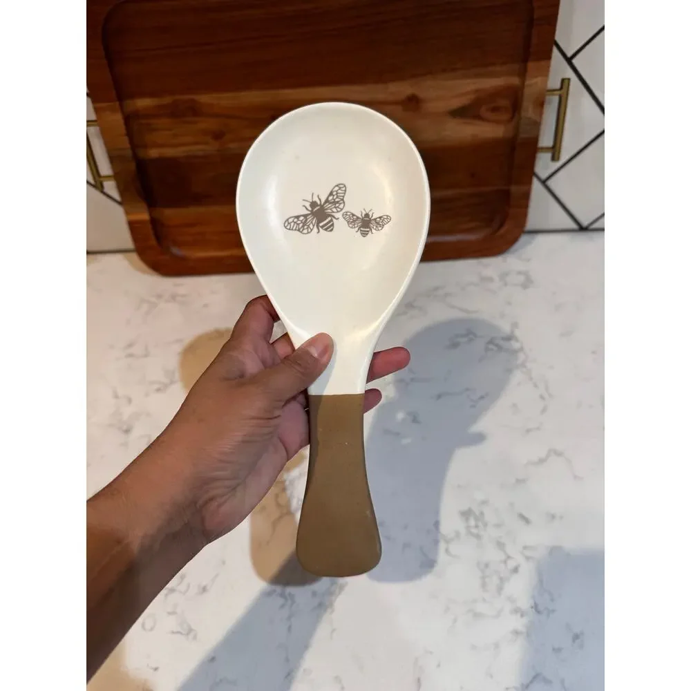 white ceramic spoon rest black bee graphic contrasting brown dipped handle
